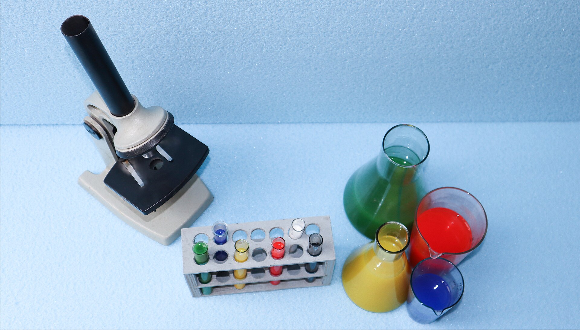 Microscope, test tubes and flasks on a laboratory bench