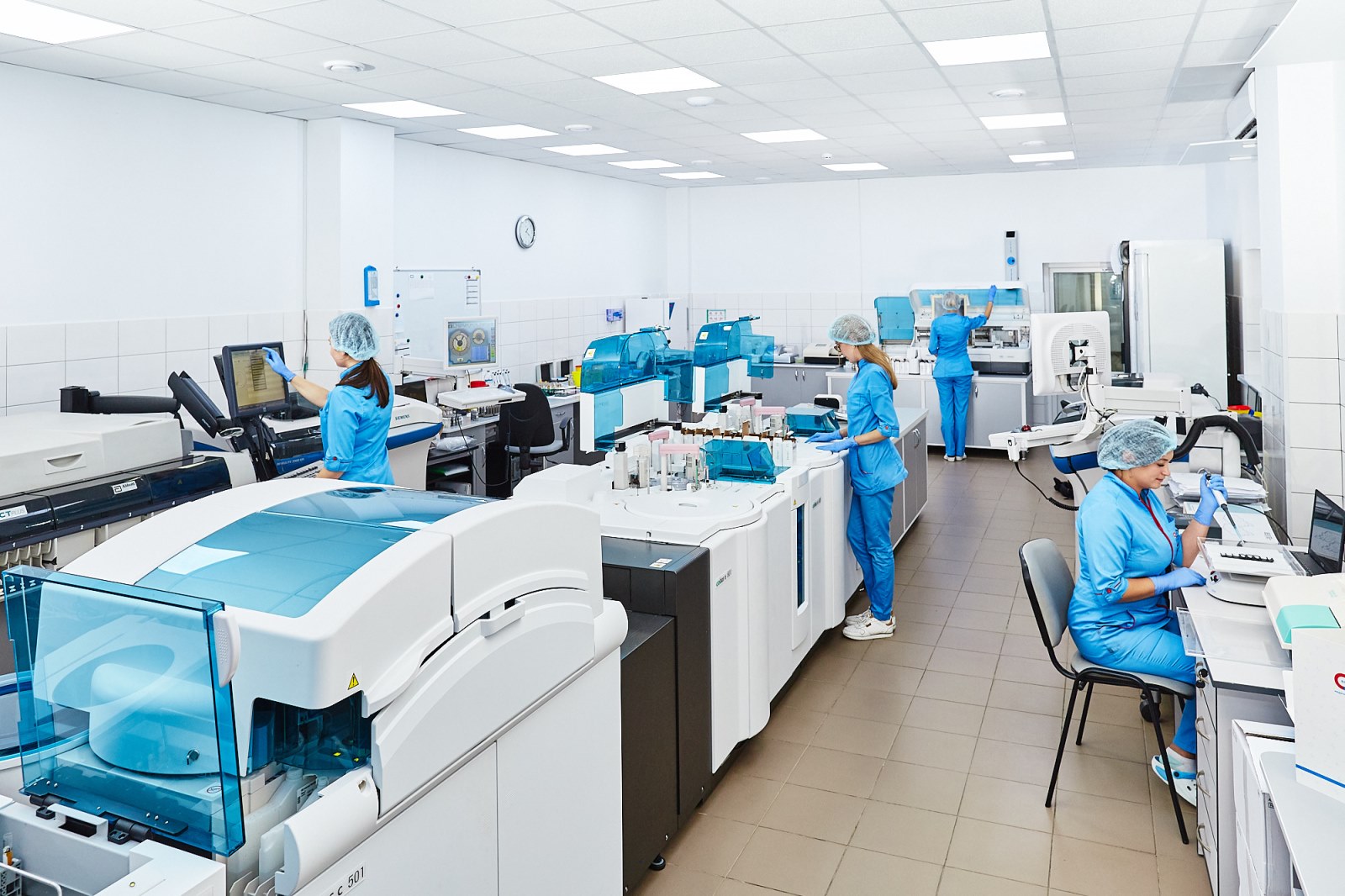 Researchers reviewing a documentation binder at a laboratory bench